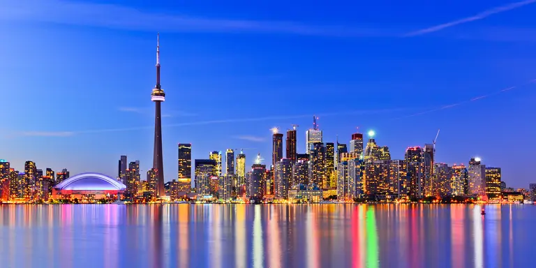 The city skyline at twilight reflecting in lake ontario