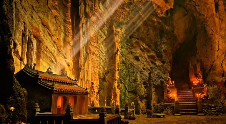 Dark cave with mystical Troglodyte temple, Huyen Khong grotto, Marble Mountains