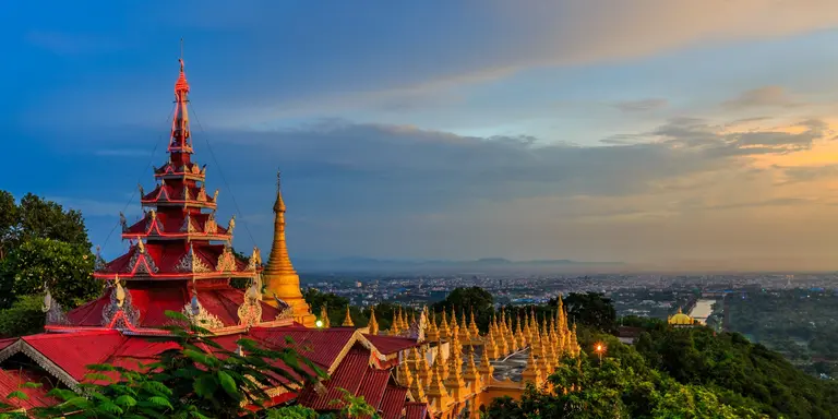 HIllside view of the red roof of Mandalay Palace and Hill