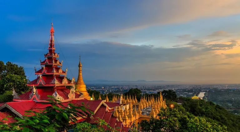 HIllside view of the red roof of Mandalay Palace and Hill