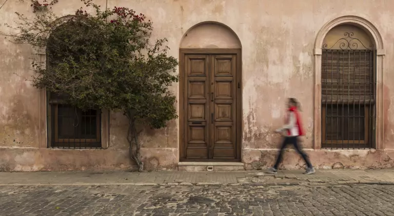Long exposure image of a woman walking on the streets in the historic district of Colonia del Sacramento in Uruguay