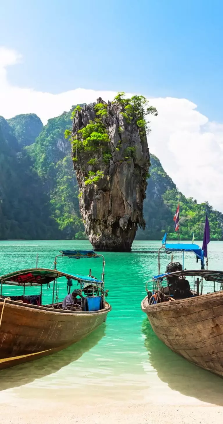 James Bond island with thai traditional wooden longtail boat and beautiful sand beach in Phang Nga bay, Thailand