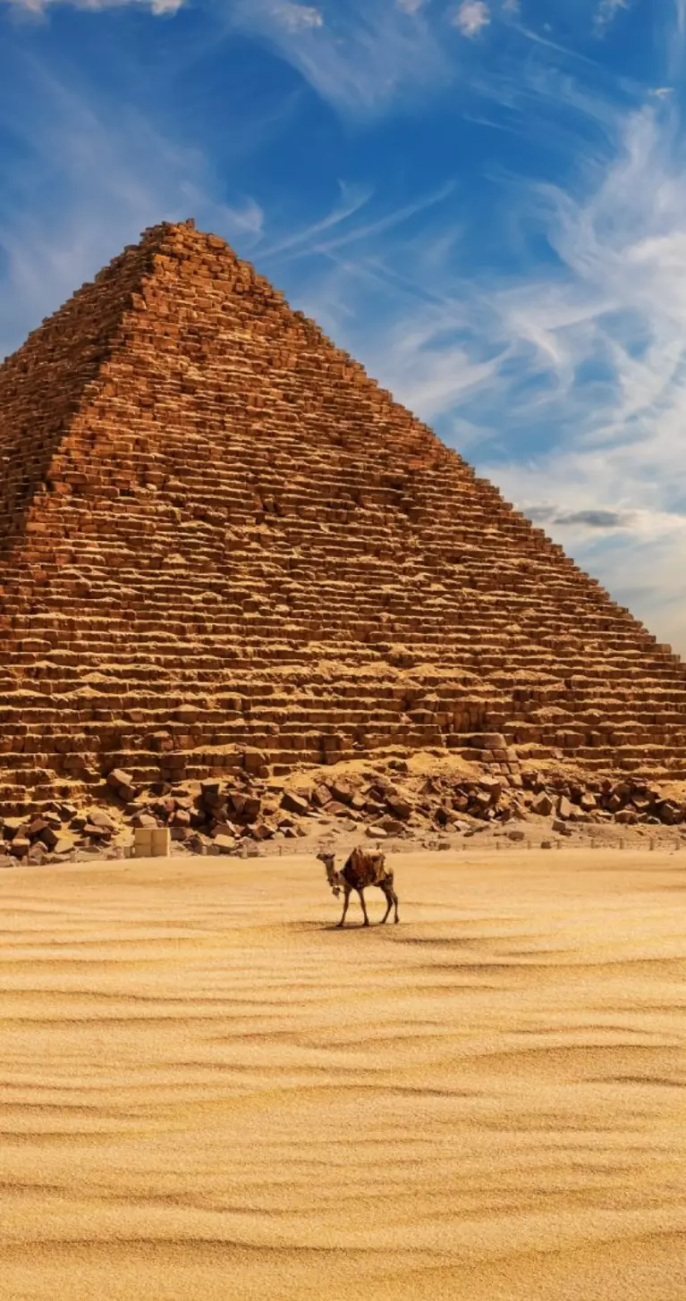 The Pyramid of Menkaure at sunset in Egypt and a camel nearby