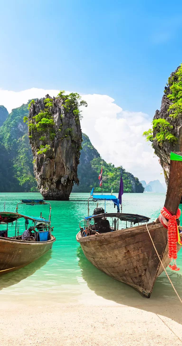 James Bond island with thai traditional wooden longtail boat and beautiful sand beach in Phang Nga bay, Thailand