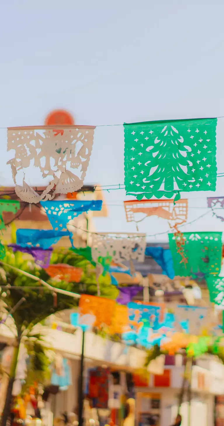 Colourful flags are waving on a shopping street in Mexico