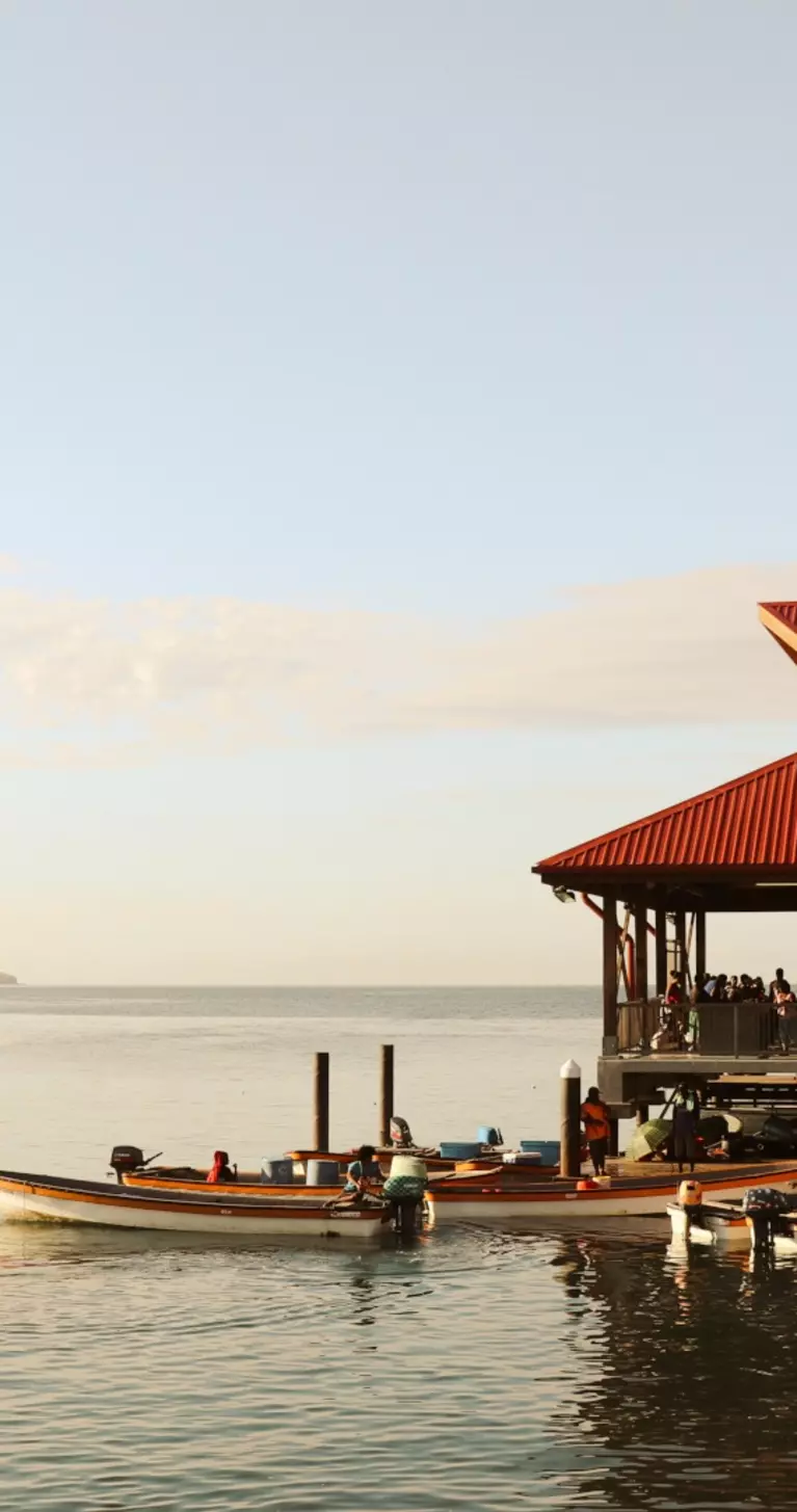Boats on dock beside oceanside Papua New Guinea market