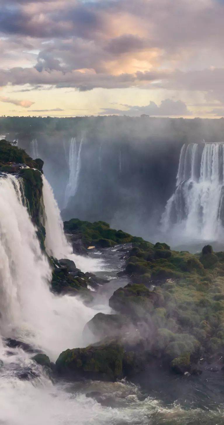 Breathtaking view of the Iguazu Falls gleaming under the cloudy sky in South America