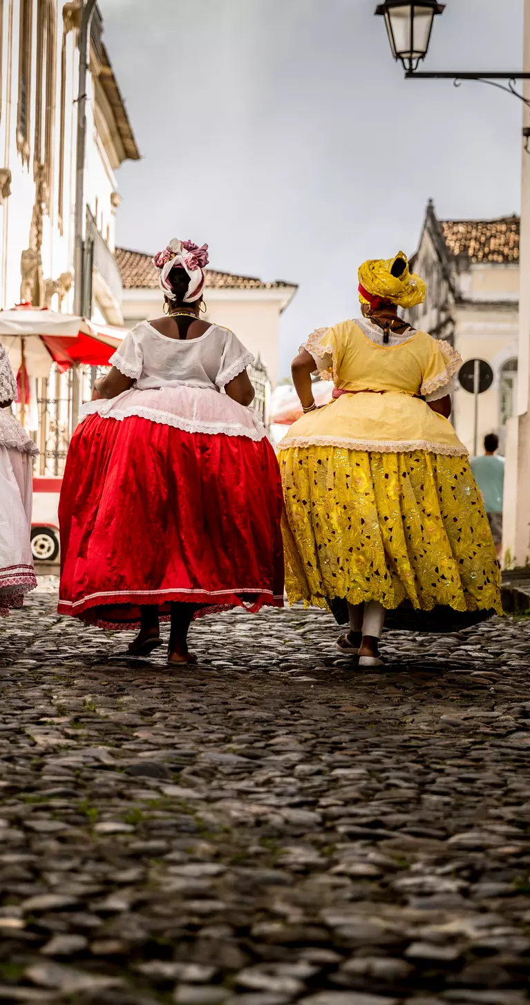 Group of "Baianas" walking in the famous Pelourinho cobblestone road in Salvador, Bahia, Brazil