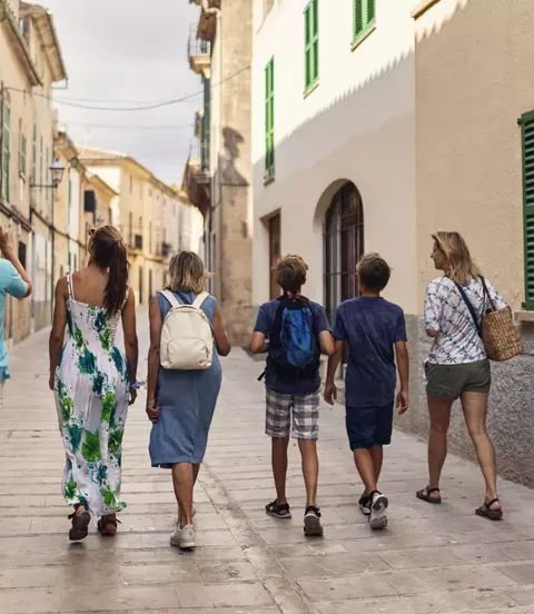 Majorca, Spain Family walking in beautiful town of Alcudia. Sunny summer day in Majorca, Spain. Mother, grandparents and three teenagers are walking in narrow street