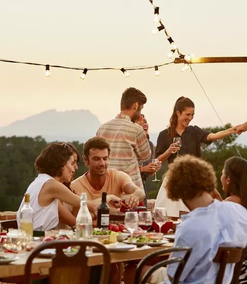 Friends enjoying at patio during social gathering at sunset in Spain