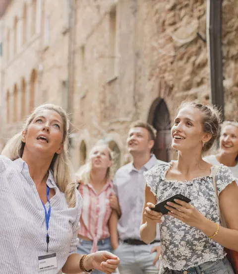 Group of people standing in a street in Volterra learning about architecture and the history
