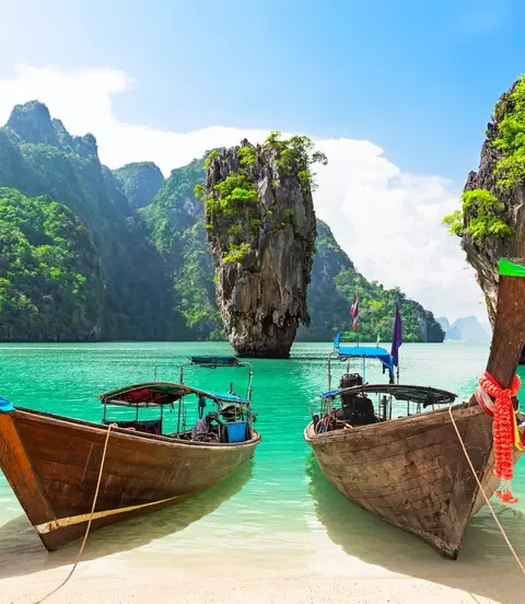 James Bond island with thai traditional wooden longtail boat and beautiful sand beach in Phang Nga bay, Thailand