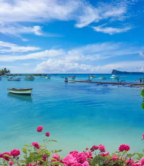 "Landscape view of the blue transparent sea, boats and beach in the summertime in Mauritius "