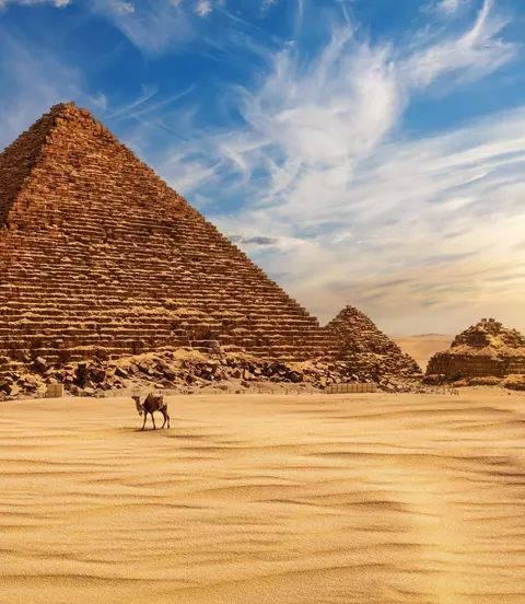 The Pyramid of Menkaure at sunset in Egypt and a camel nearby