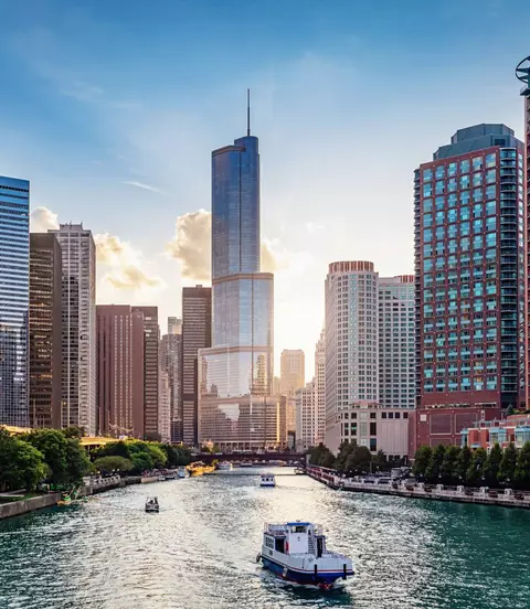 Cityscape from Chicago River Waterfront at Dusk. Small boats and tourist ferries cruising towards the Michigan Lake