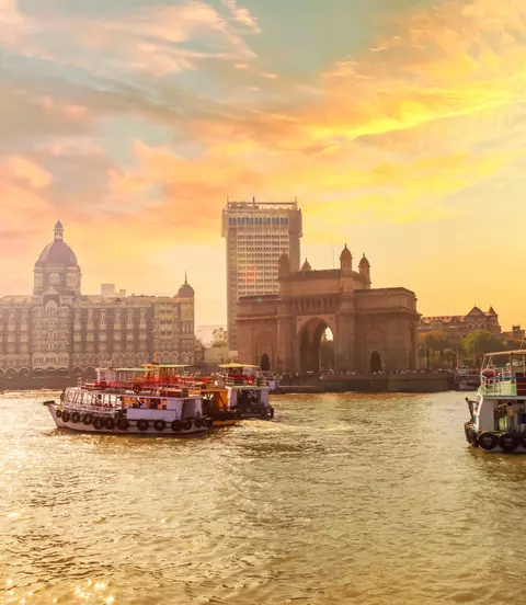 Mumbai Harbor with beautiful warmly lit sky, Gate of India along with Taj and keeping the boats in the foreground