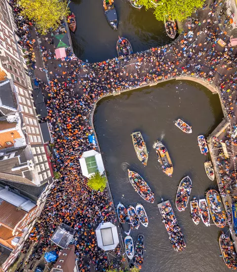 Canal boat parade on Koningsdag Kings day festivities in Amsterdam. Birthday of the king