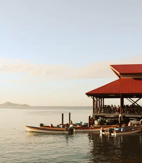 Boats on dock beside oceanside Papua New Guinea market