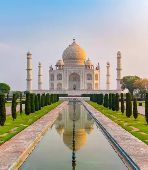 Taj Mahal front view reflected on the reflection pool, an ivory-white marble mausoleum Agra, Uttar Pradesh, India. One of the seven wonders of the world