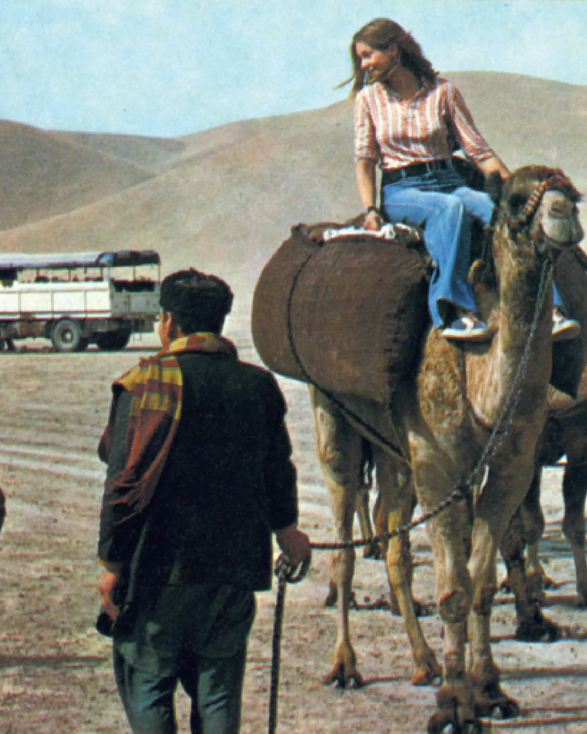A woman rides a camel in a vintage photo of exploring Afghanistan