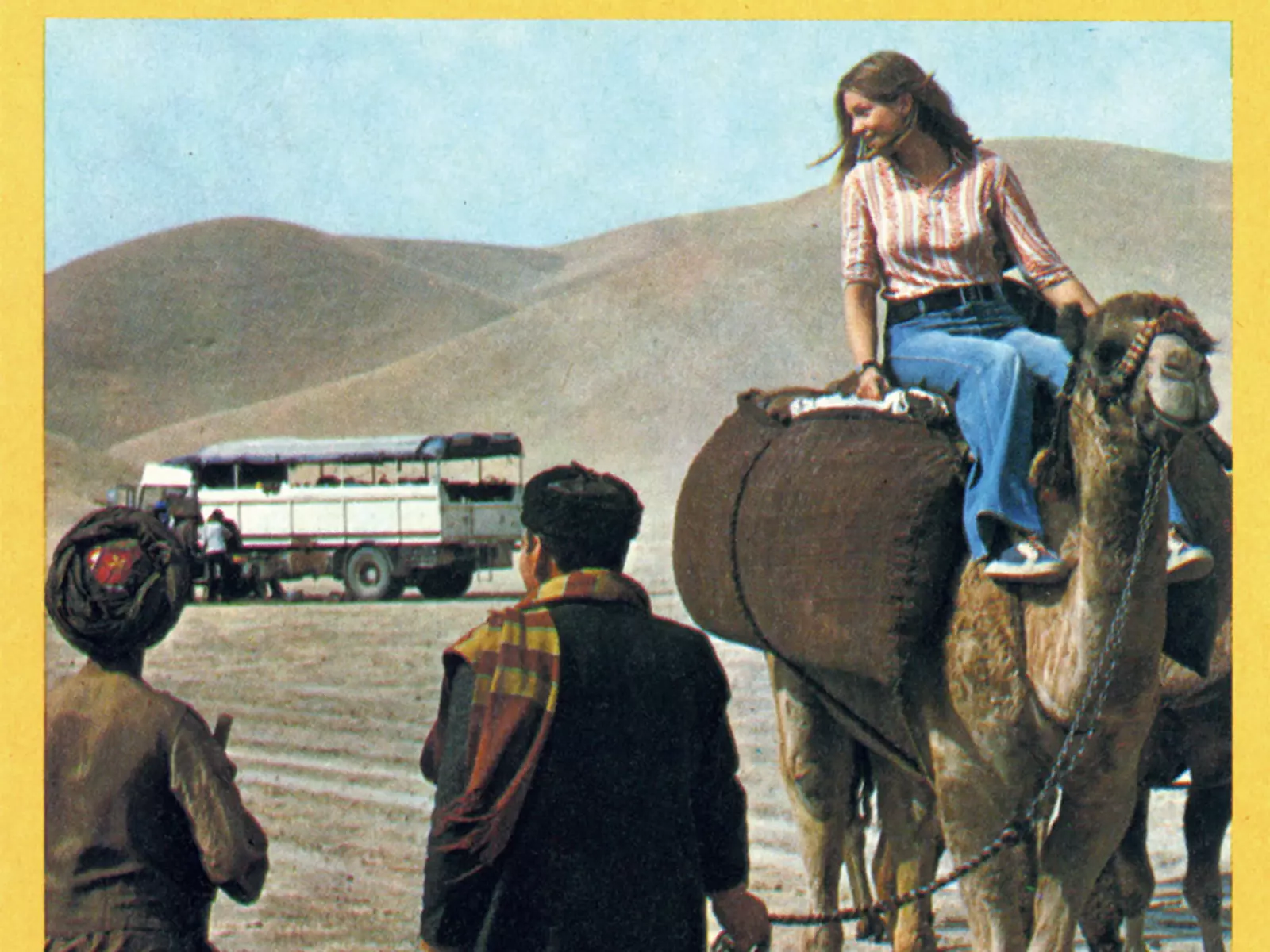 A woman rides a camel during an overland tour to Afghanistan.