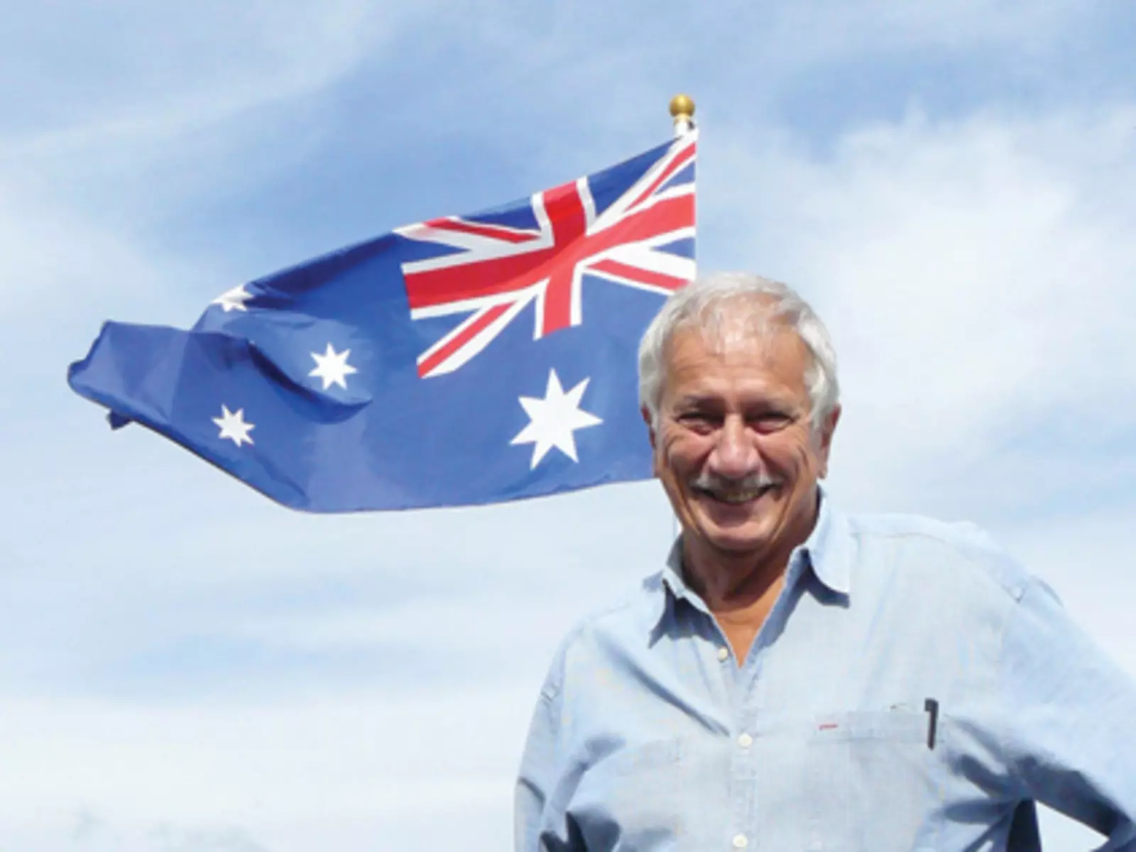 Bruce Hodge poses with the Australian flag on the roof of the Goway office.