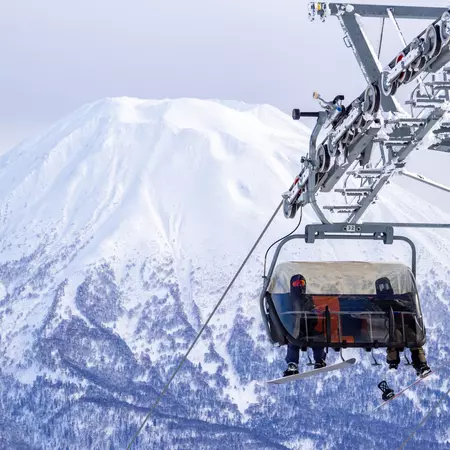 Chairlift with a snowy volcano in background 