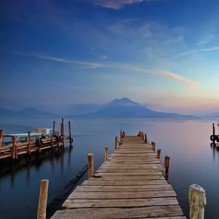 Colourful sunset at the Panajachel Pier with volcanoes in the background, Lake Atitlan, Guatemala
