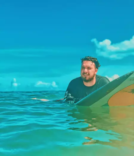 Scott Tindale on a surfboard in the ocean.