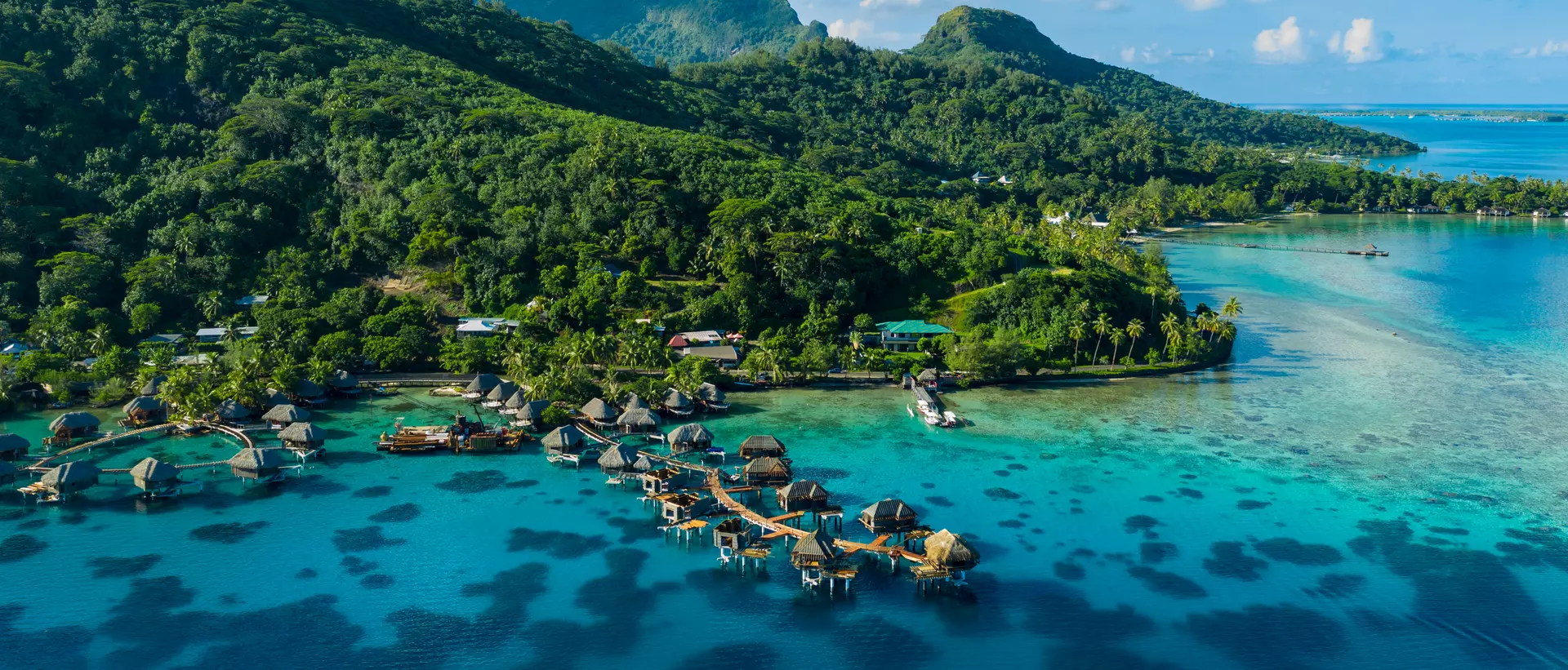 aerial view of resorts and green mountains with blue waters