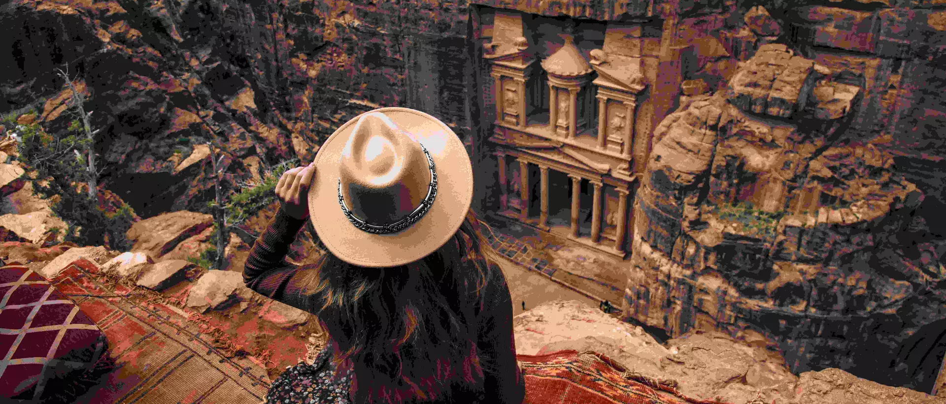 woman sitting on edge of cliff overlooking Petra