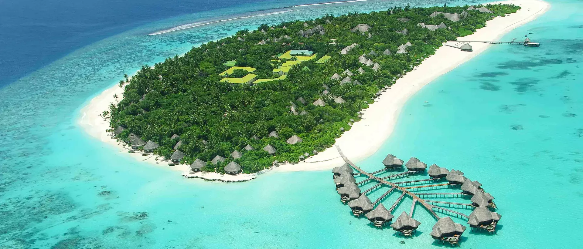 aerial view of overwater bungalows and white-sand beach island