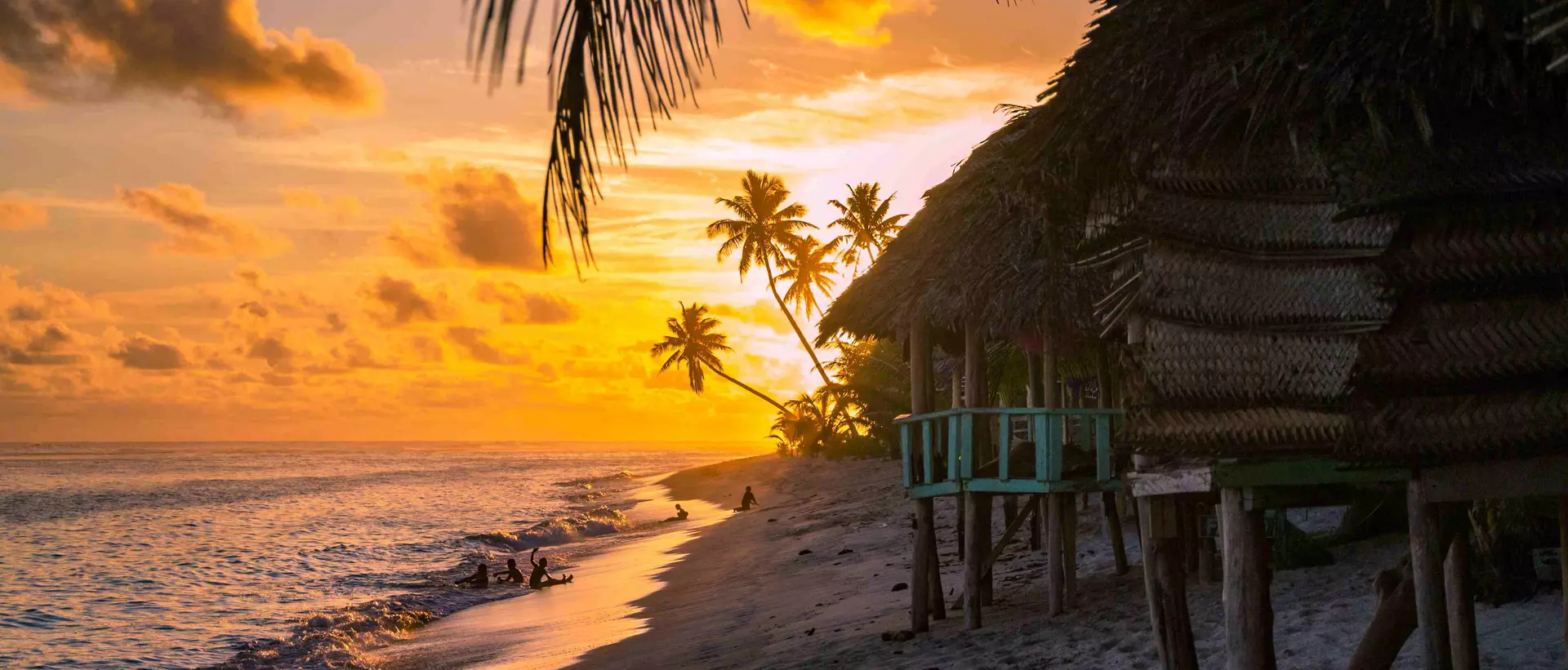 beach bungalows during sunset with ocean calmly lapping the sand