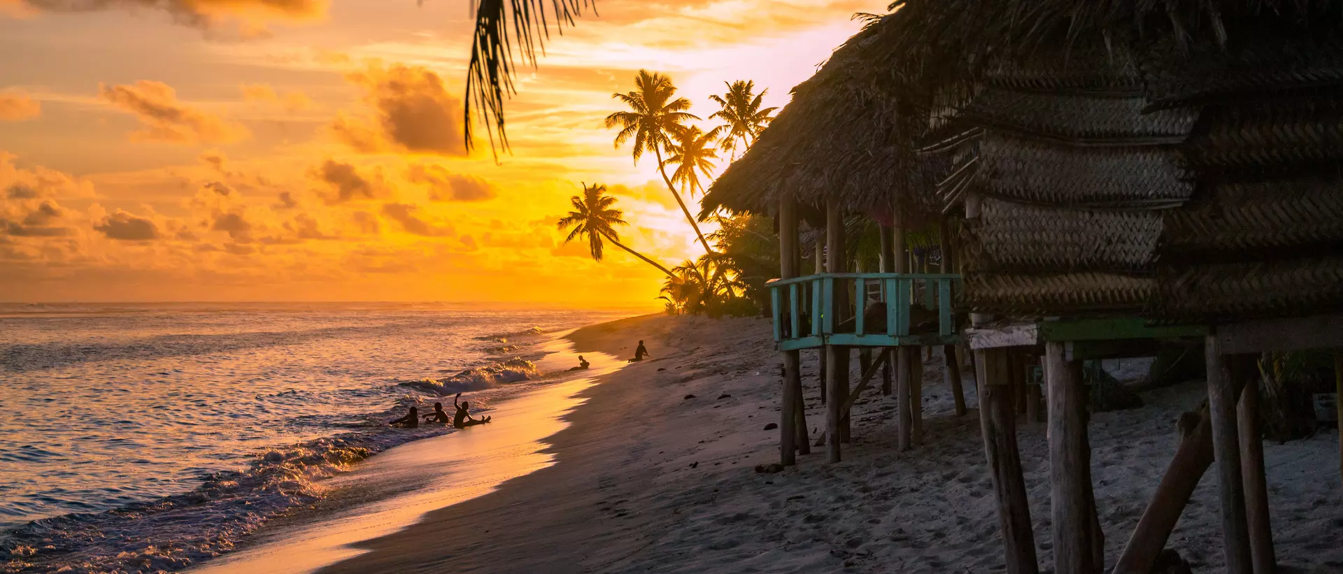 beach bungalows during sunset with ocean calmly lapping the sand