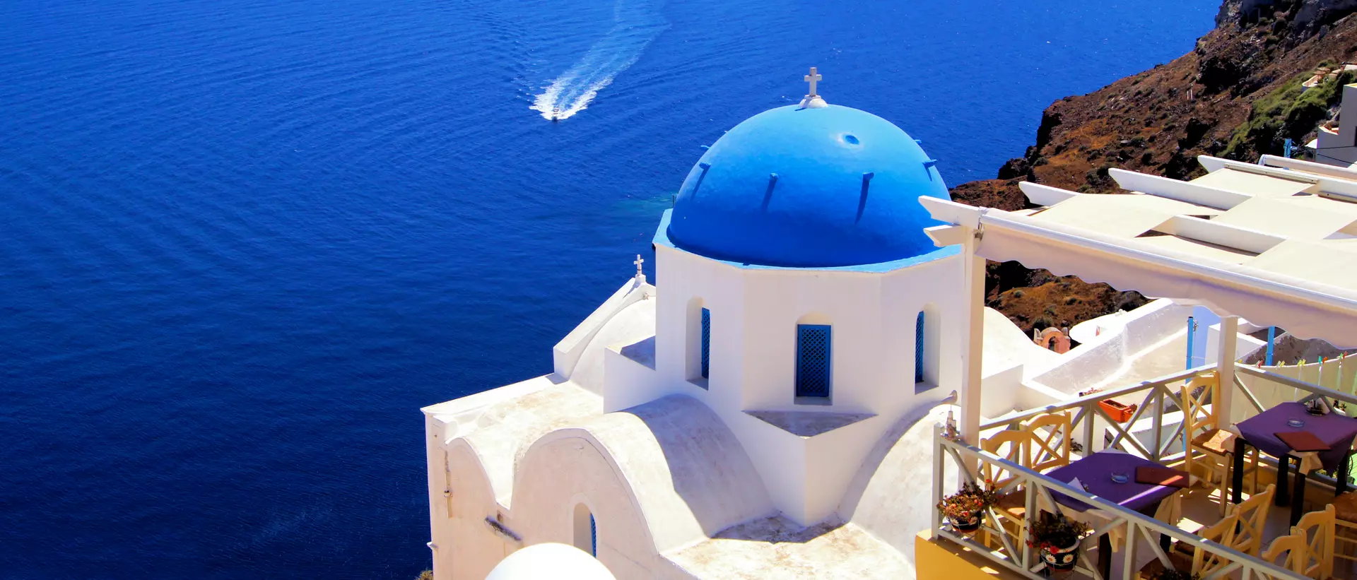 Blue dome church with boat, Oia village, Greece
