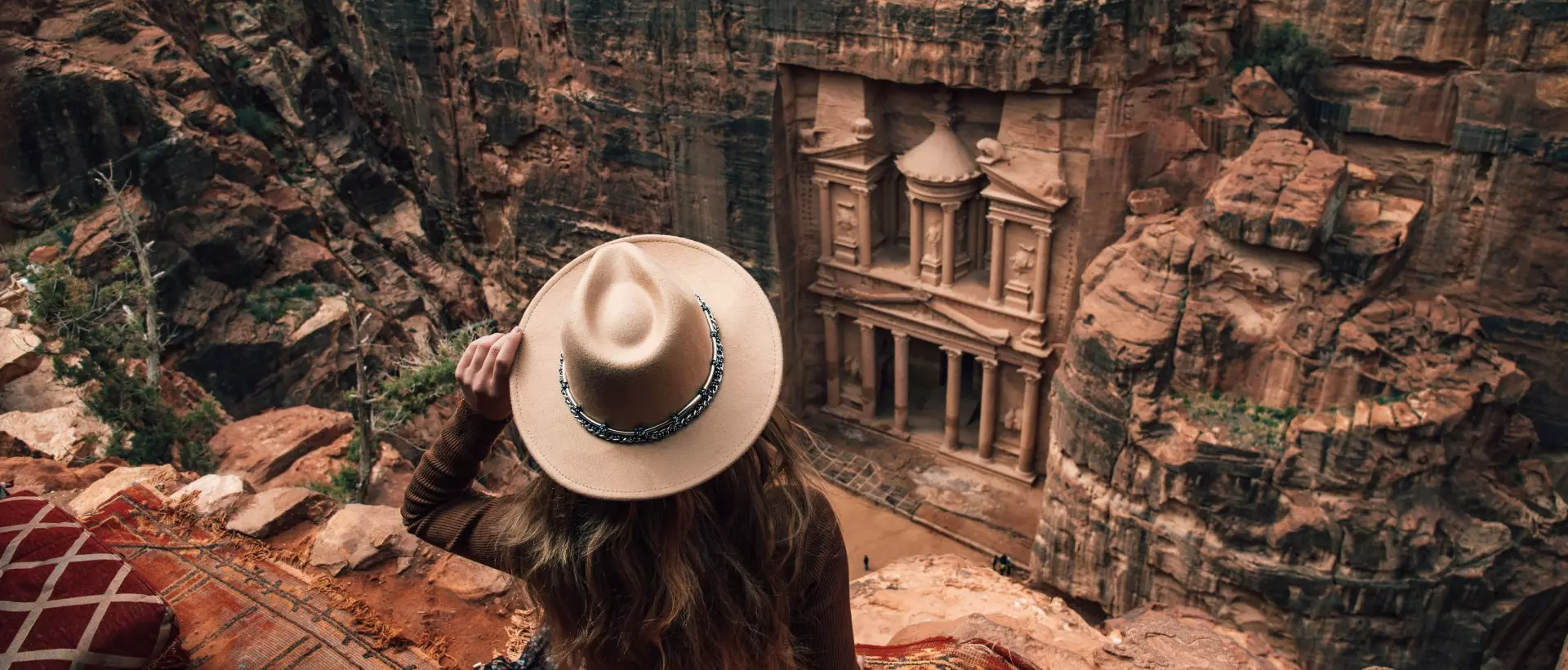 woman sitting on edge of cliff overlooking Petra