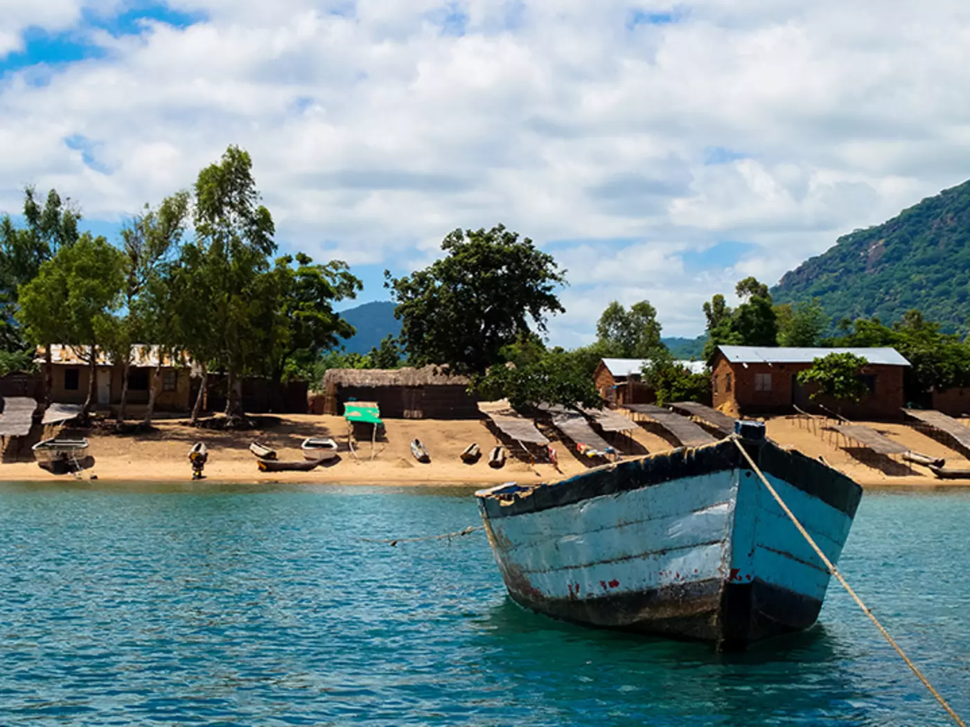 Set sail on Lake Malawi, enjoying the blue waters against the lush green mountains