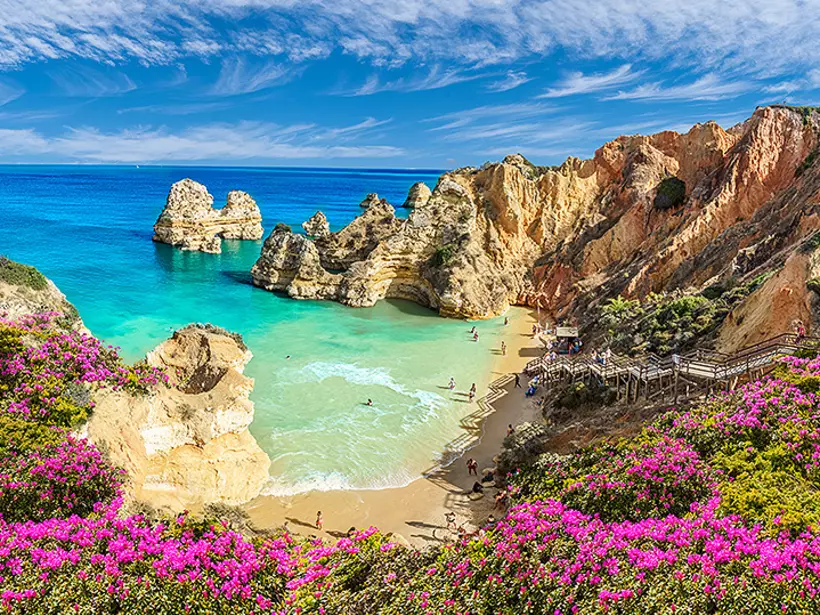 Experience the ultimate beach experience at Praia do Camilo, a sandy cove with picturesque blue waters