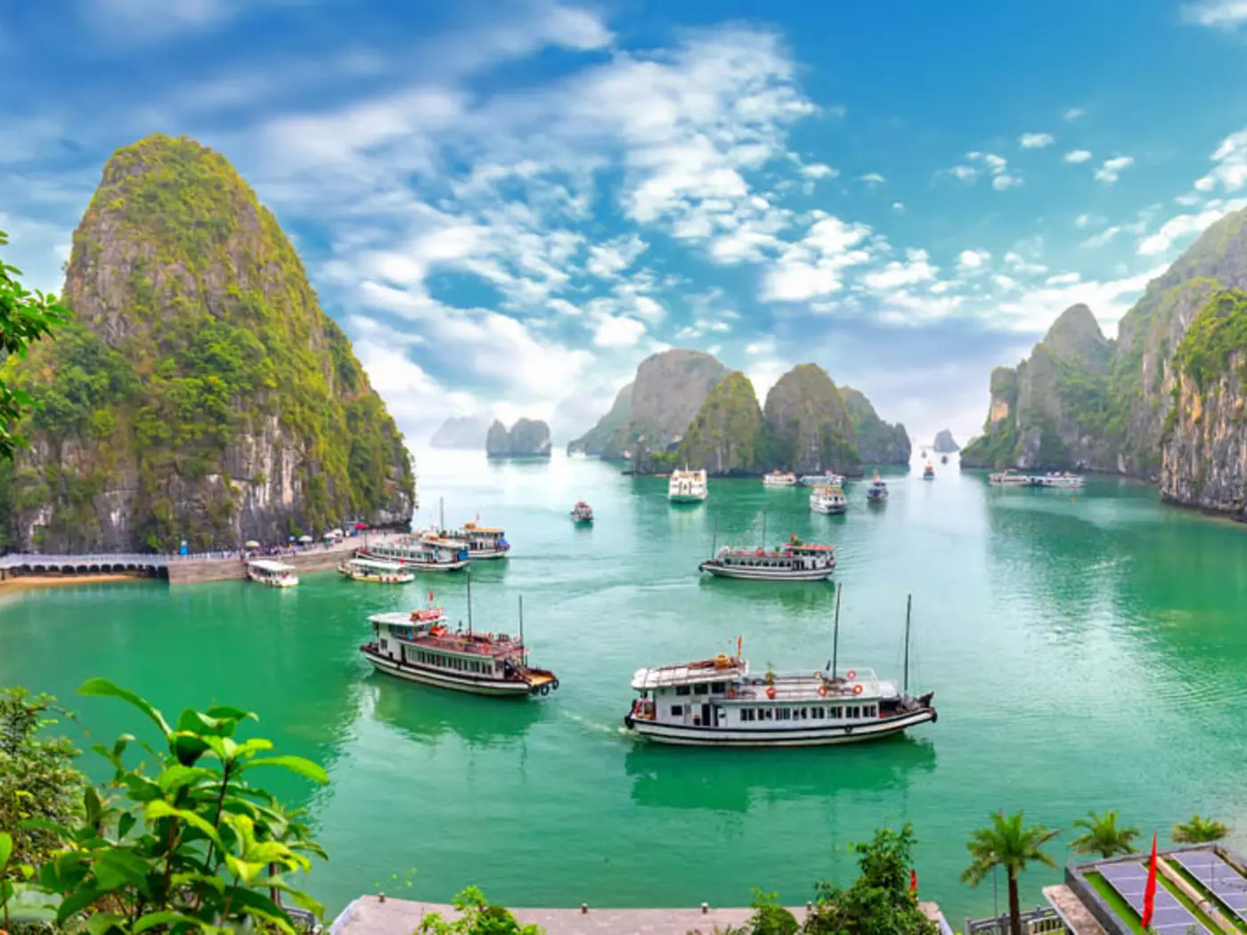 Limestone pillars and tiny islands dot the emerald waters of Halong Bay