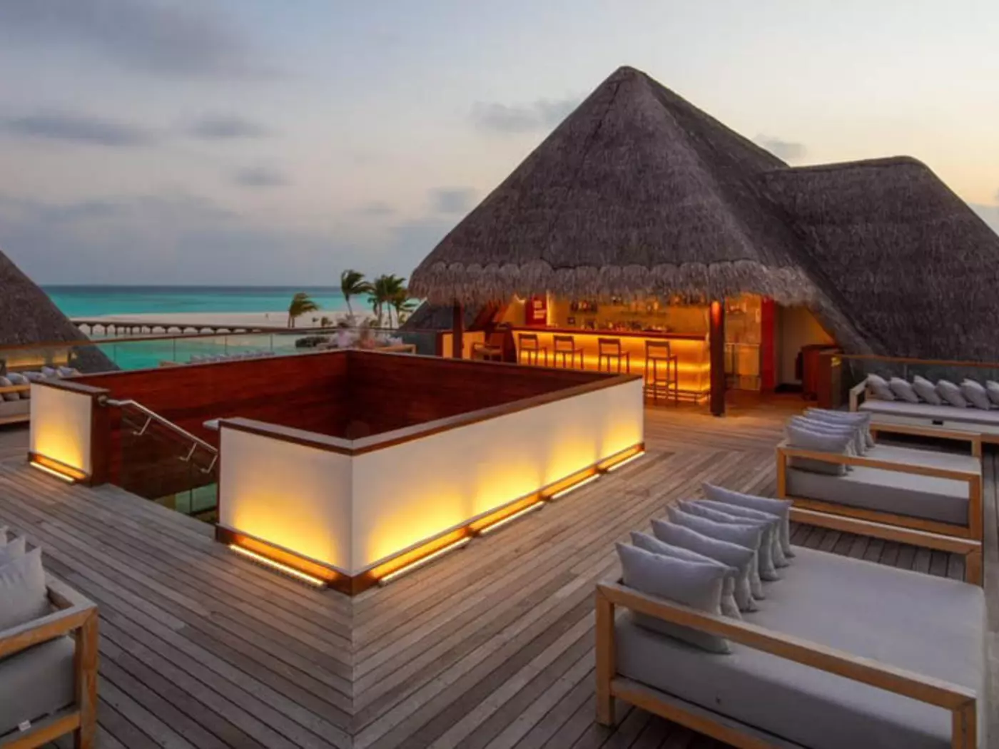 Sip on a refreshing cocktail from Heritance Aarah's sky bar as the sun sets in the distance