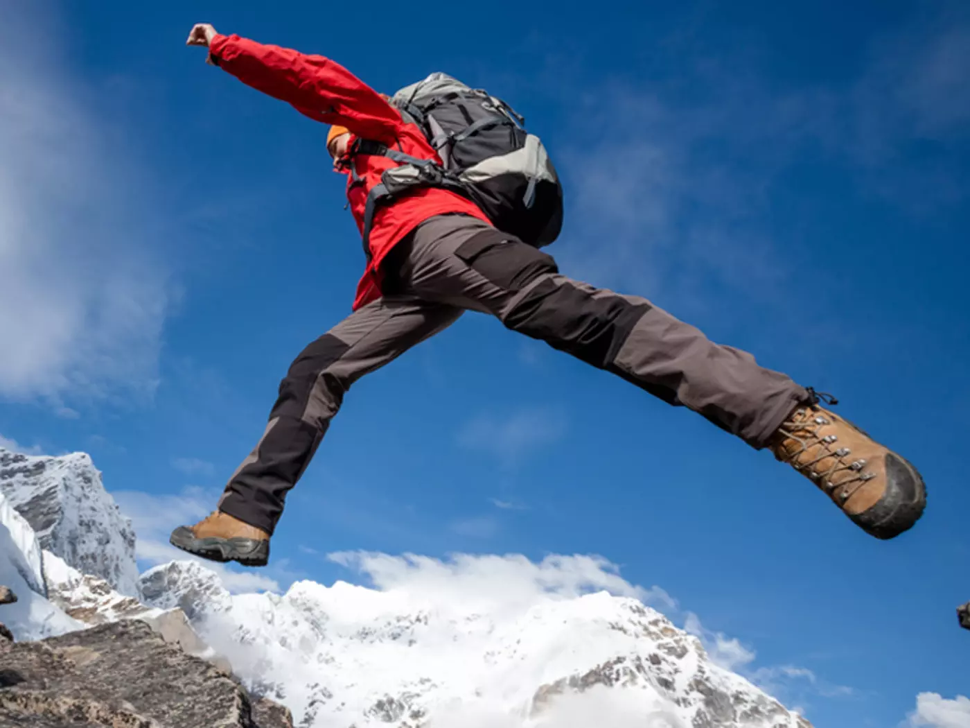 Hiker jumps on a rock near Everest in Nepal