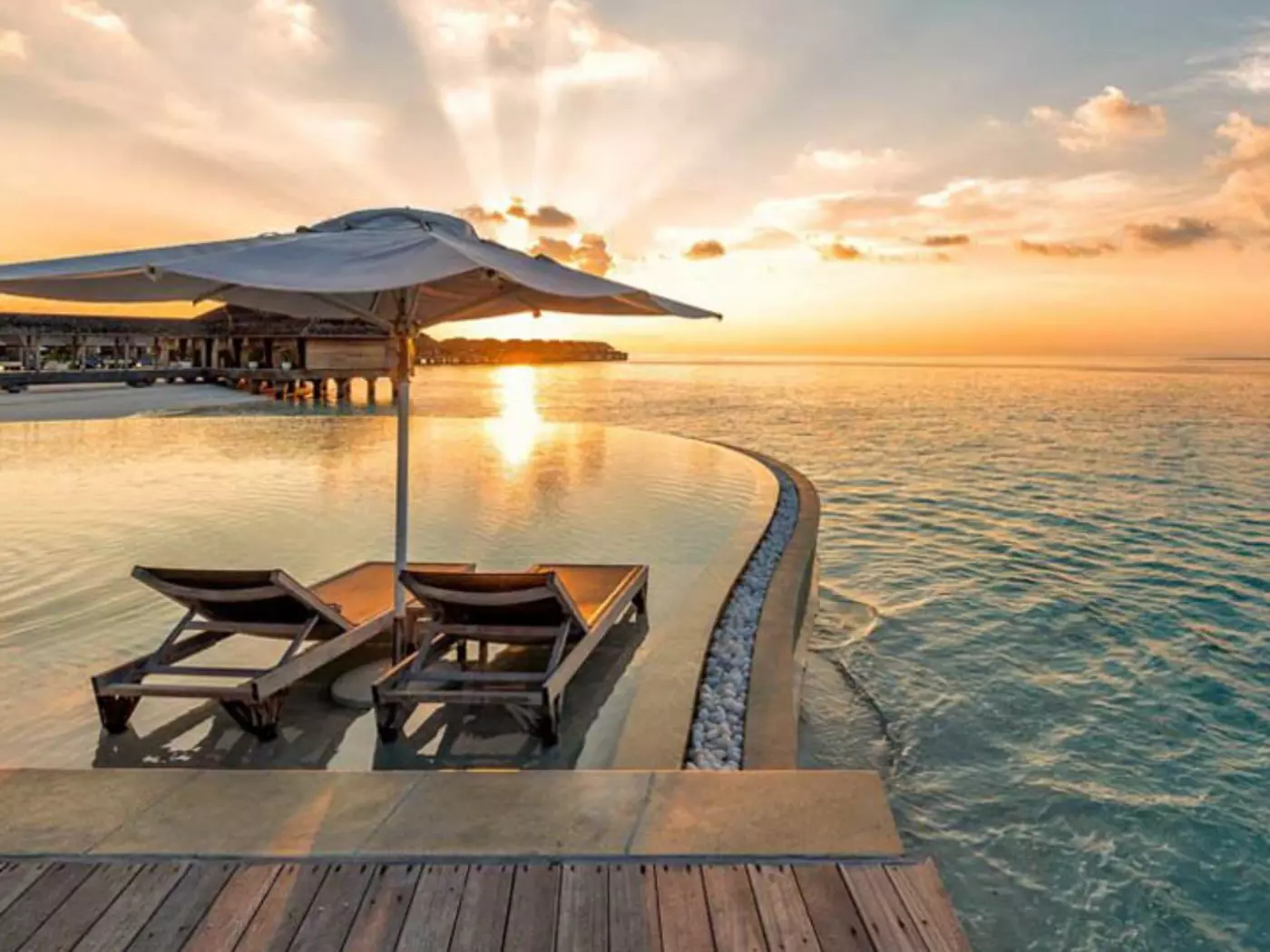 Experience a scenic sunset while basking in the luxury of the Hurawalhi Island Resort