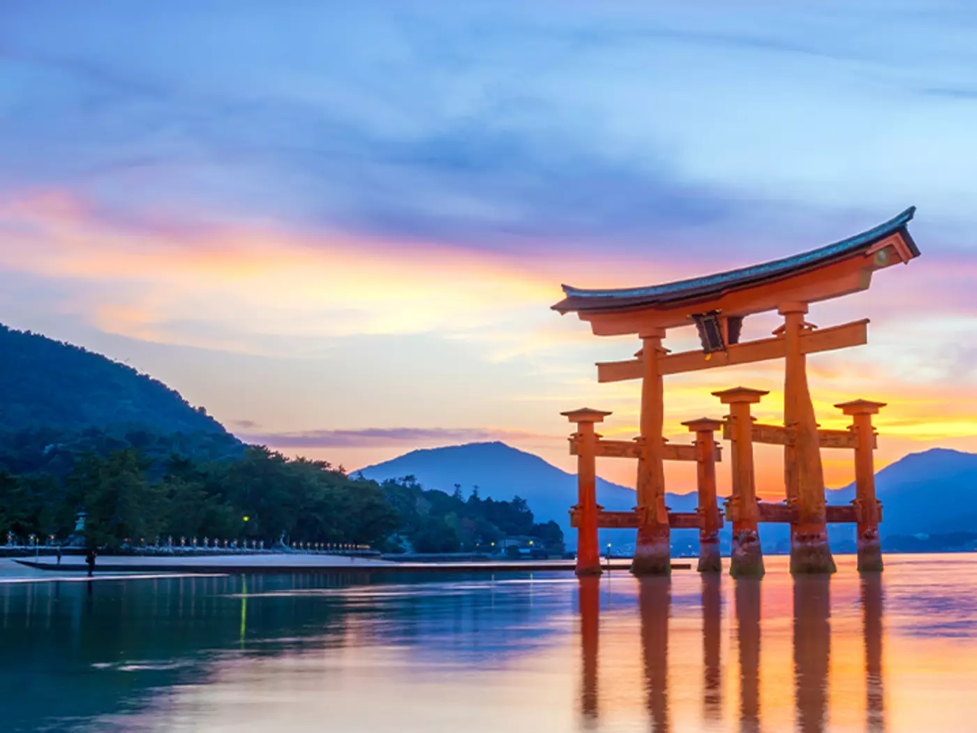 Take a detour to Miyajima Island to explore its ancient architecture, lush forests. and iconic floating gate