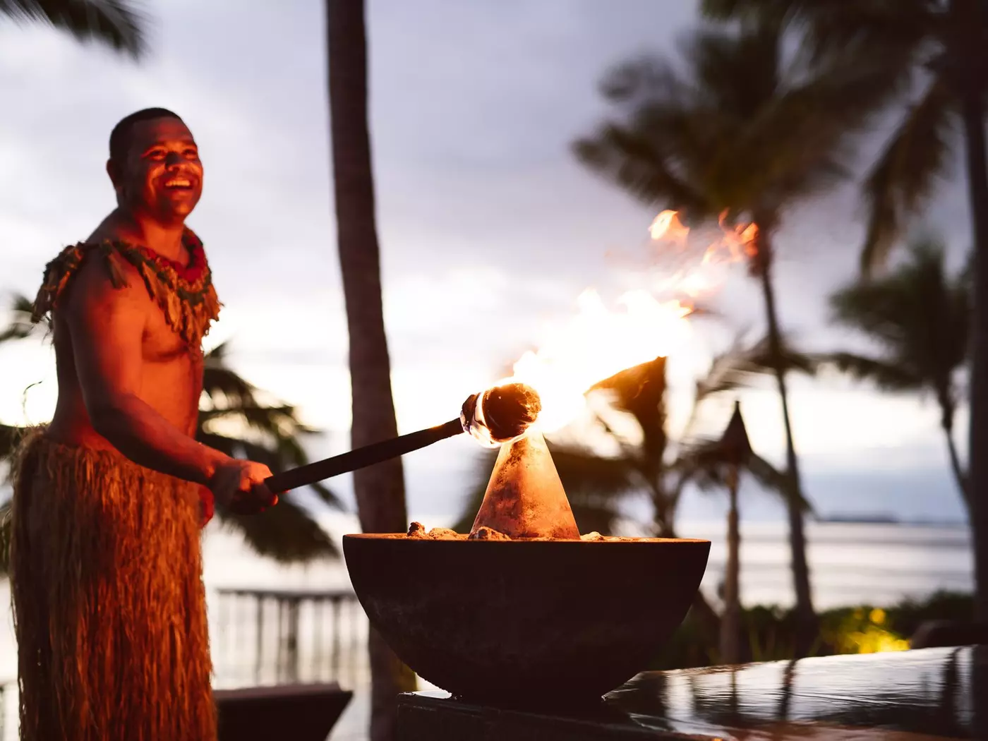 Warrior greeting dusk at the torch lighting ceremony, Tokoriki Island Resort