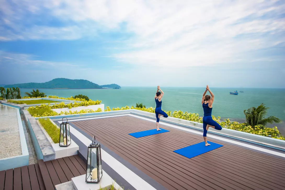 Two people doing yoga on a vacation at the Amatara Wellness Resort, Thailand.
