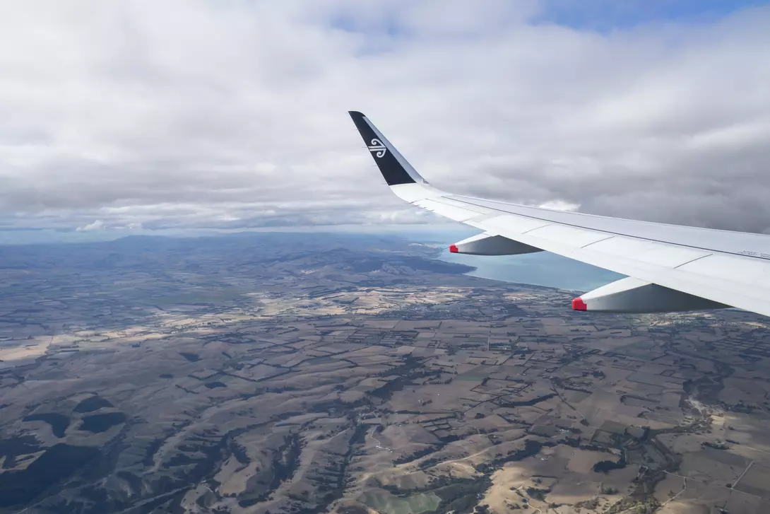 Aerial view of an airplane wing with Air New Zealand logo. Flying above the Canterbury. Image taken on Air NZ flight from Auckland to Christchurch