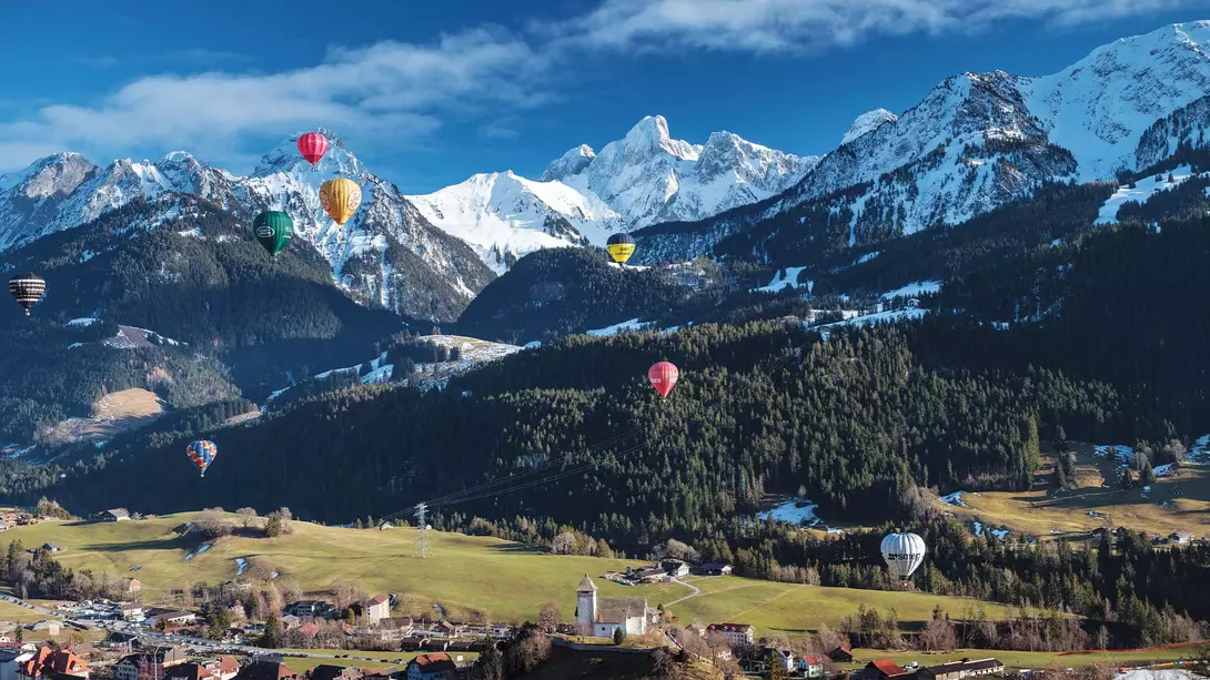 View of hot air balloons over the Swiss Alps in Switzerland.