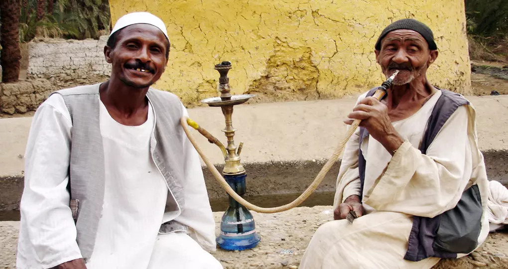 Men smoke from a shisha pipe Men smoke from a shisha pipe