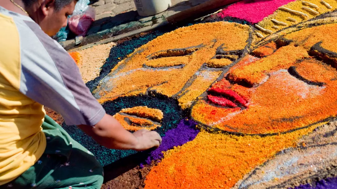 Artists create colorful "carpets" using sawdust and other materials, depicting images in the story of Easter