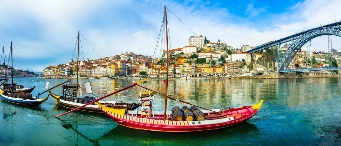 Panorama of beautiful Porto with traditional boats on the river